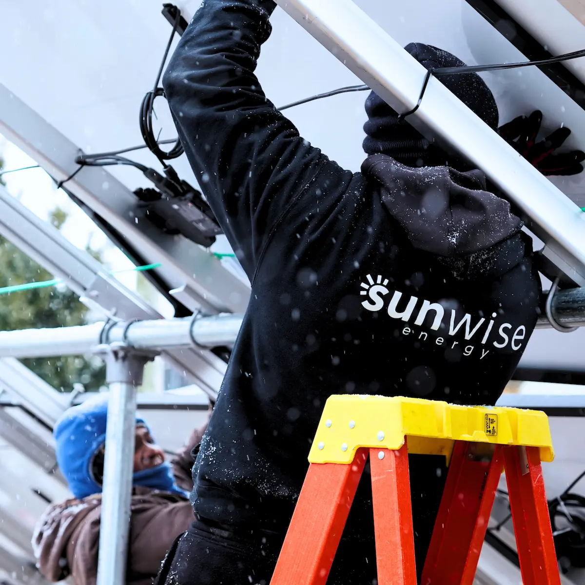 installer in sunwise gear putting in ground mount solar panels for residential commercial system