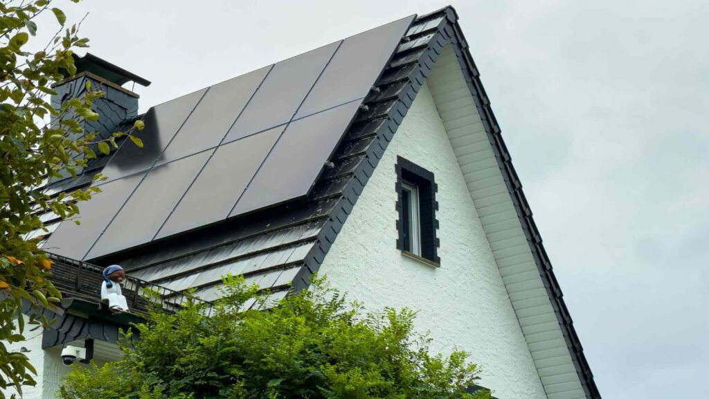 residential home with panels on gray shingled roof
