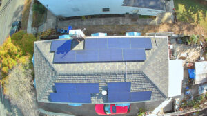 Aerial view of a house with solar panels installed, raising the question of whether to buy used solar panels.