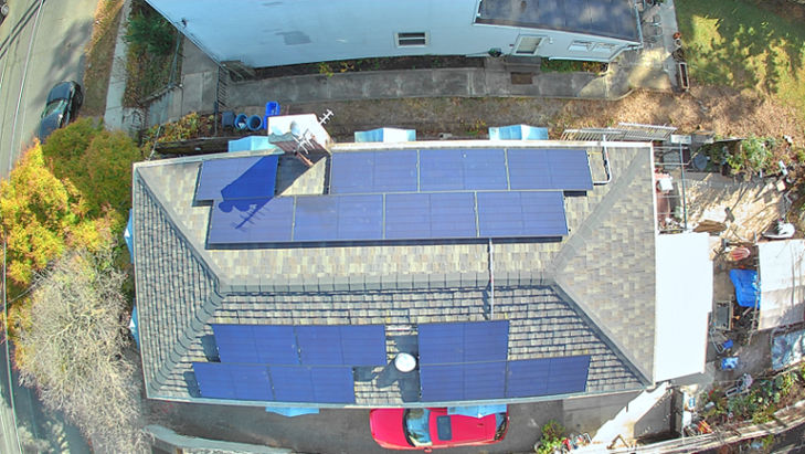 Aerial view of a house with solar panels installed, raising the question of whether to buy used solar panels.