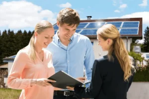 Three people discussing solar panels outdoors.